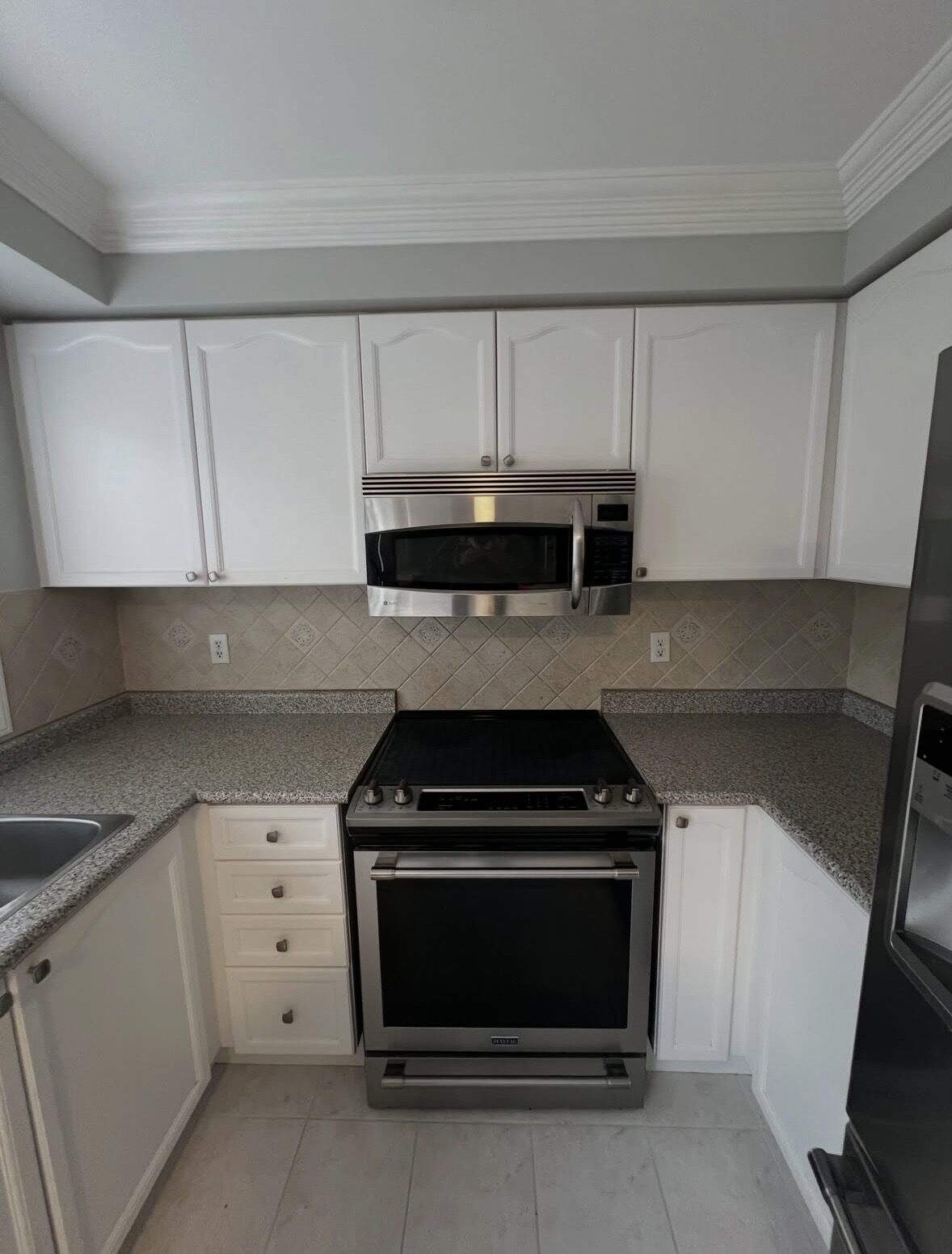 Kitchen before renovation — dated cabinetry and laminate countertops