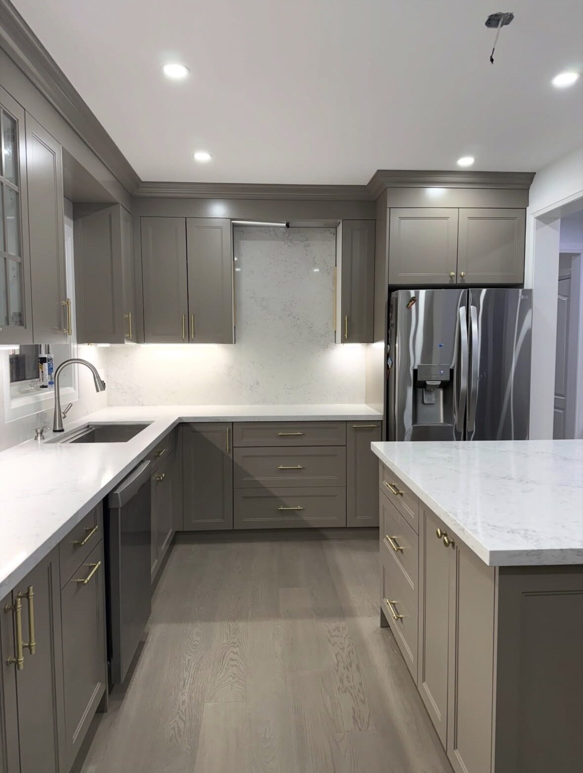 Completed kitchen renovation — taupe cabinetry with gold hardware and quartz countertops, Sarasota Building Co.