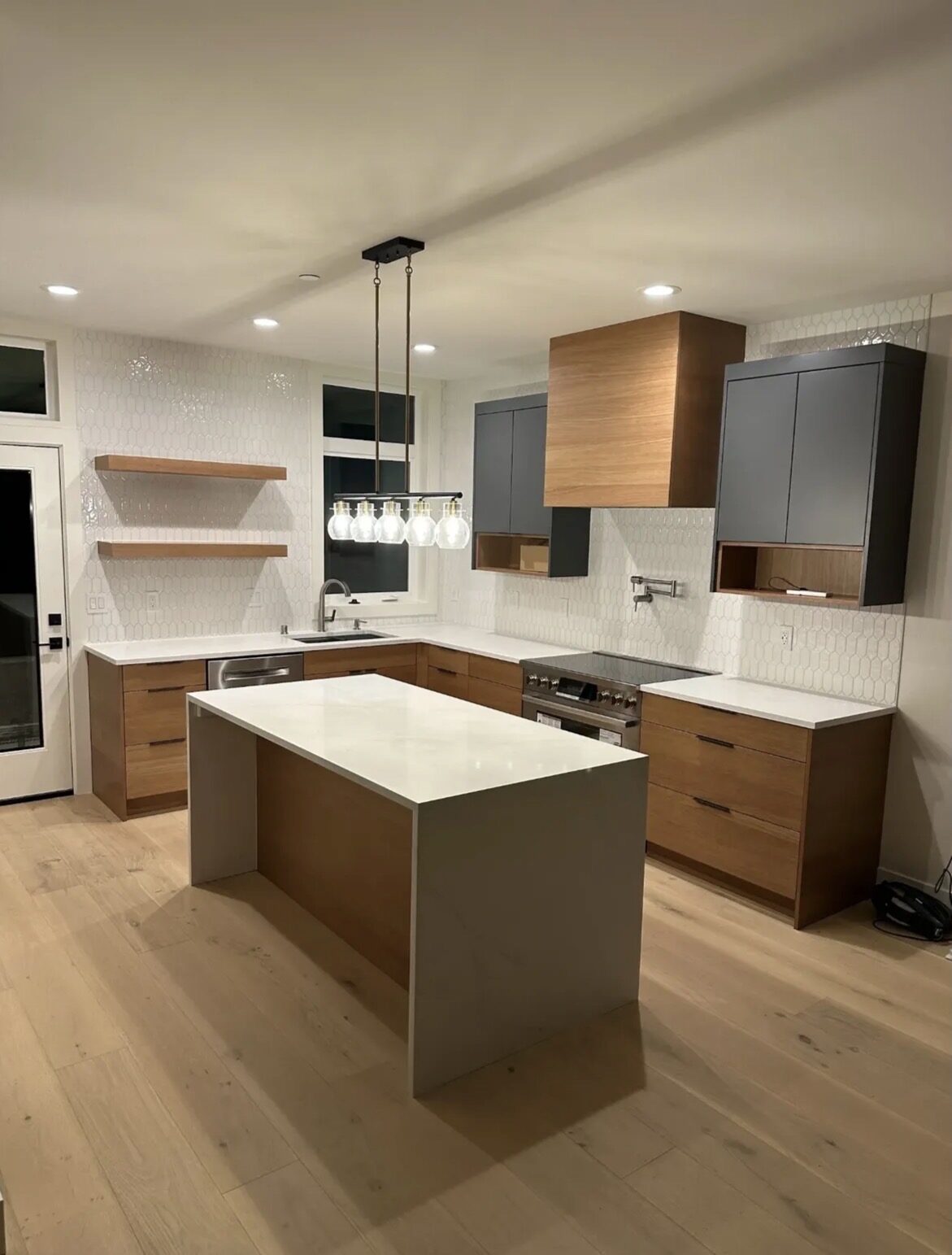 Custom walnut and charcoal cabinetry installation — modern kitchen build by Sarasota Building Co.