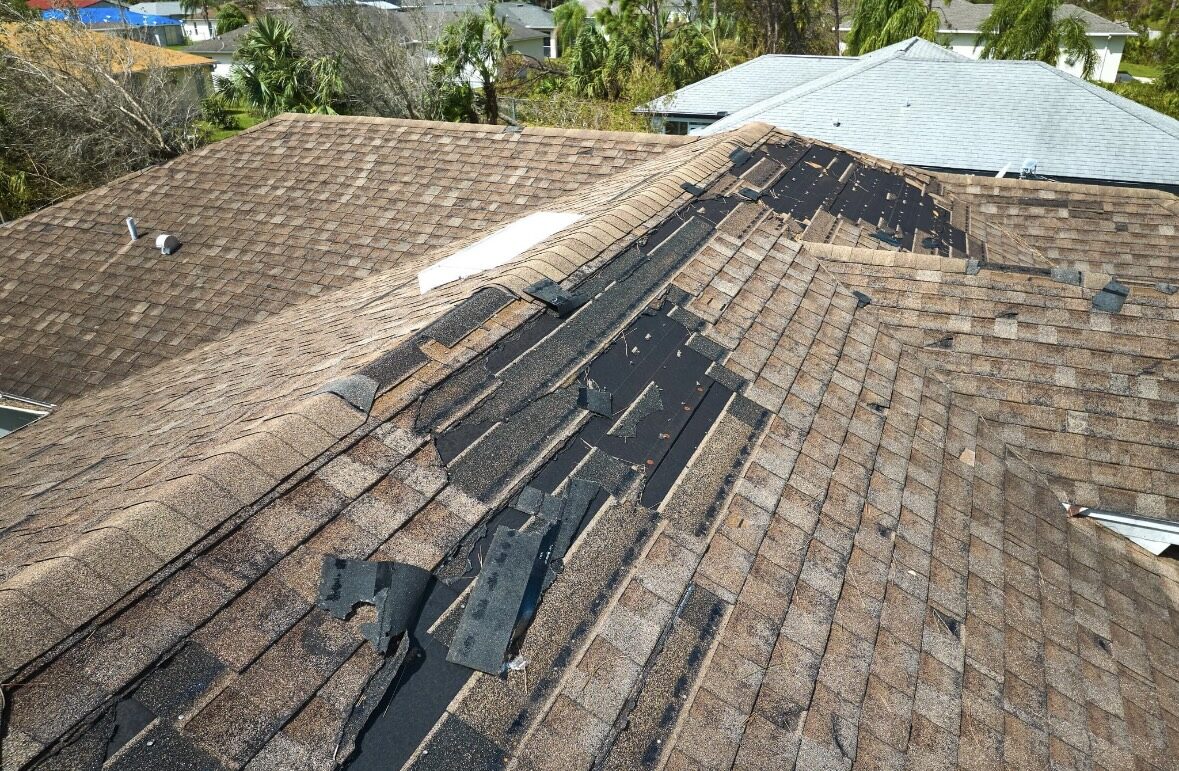 Wind-damaged shingle roof after a Southwest Florida storm, before repair by Sarasota Building Co.